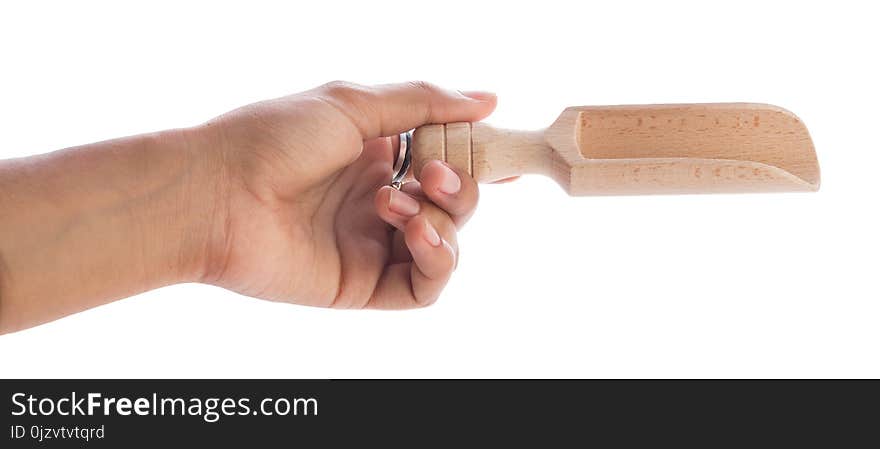 Hand holding a wooden spoon with spice on white background