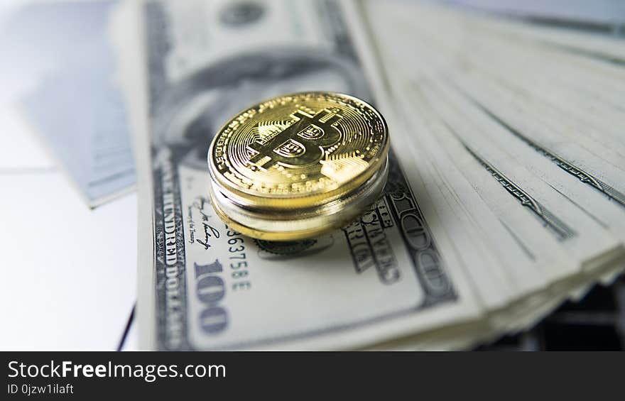 Bitcoin coin with laptop and us dollars. Bitcoin golden coins on a dollar banknotes and laptop. Cryptocurrency