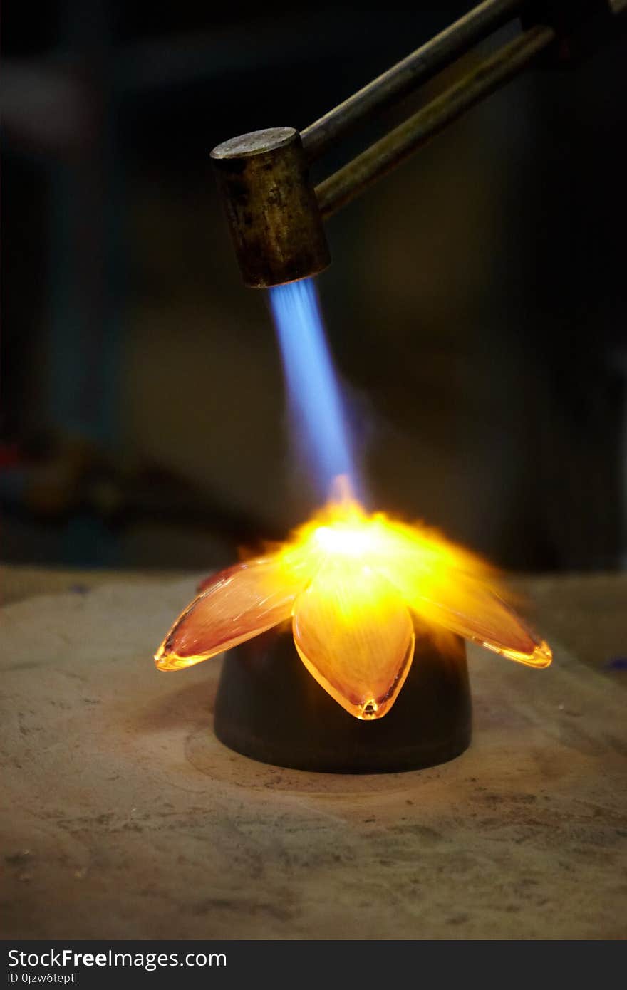 Glass-blower burns glass flower at a factory in Norway