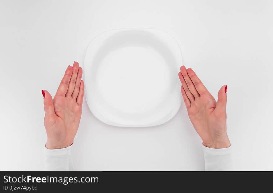 Female hands and an empty plate. A place to place your image.