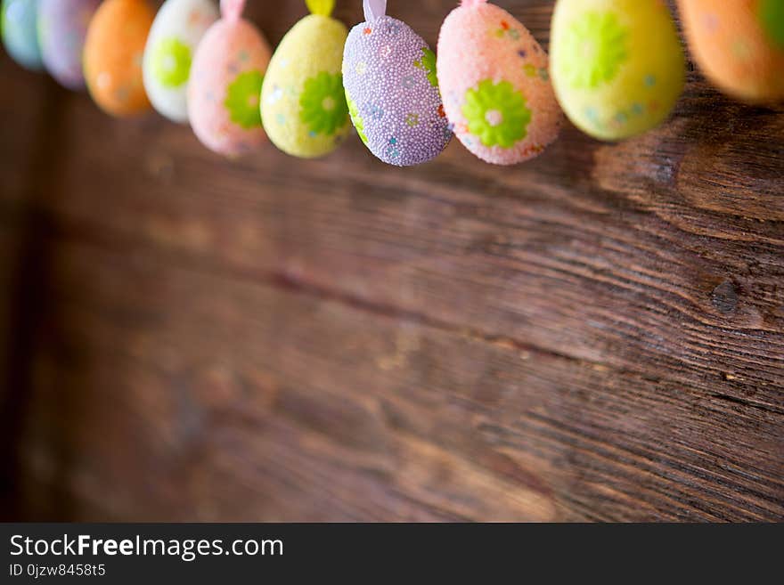 Handmade Easter Garland With Painted Eggs On Wooden Background. Colorful Easter Holiday Decoration On Rustic Wall