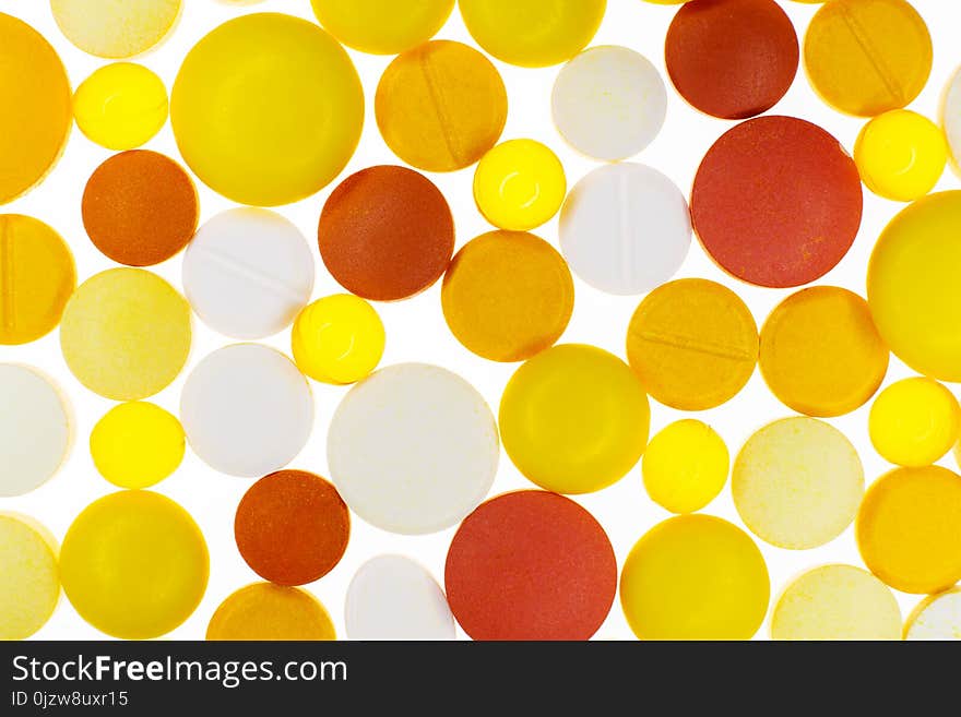 Many colorful medication pills on a white bright backlighting background. Many colorful medication pills on a white bright backlighting background.