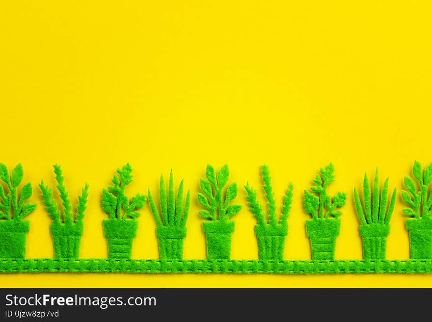 Silhouettes of green pots with plants on yellow background.