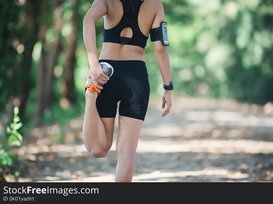 Fitness runner woman is stretching before jogging.