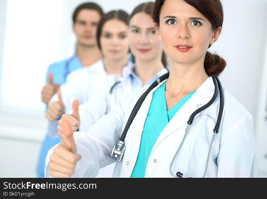 Group of doctors showing OK or approval sign with thumb up. High level and quality medical service, best treatment and