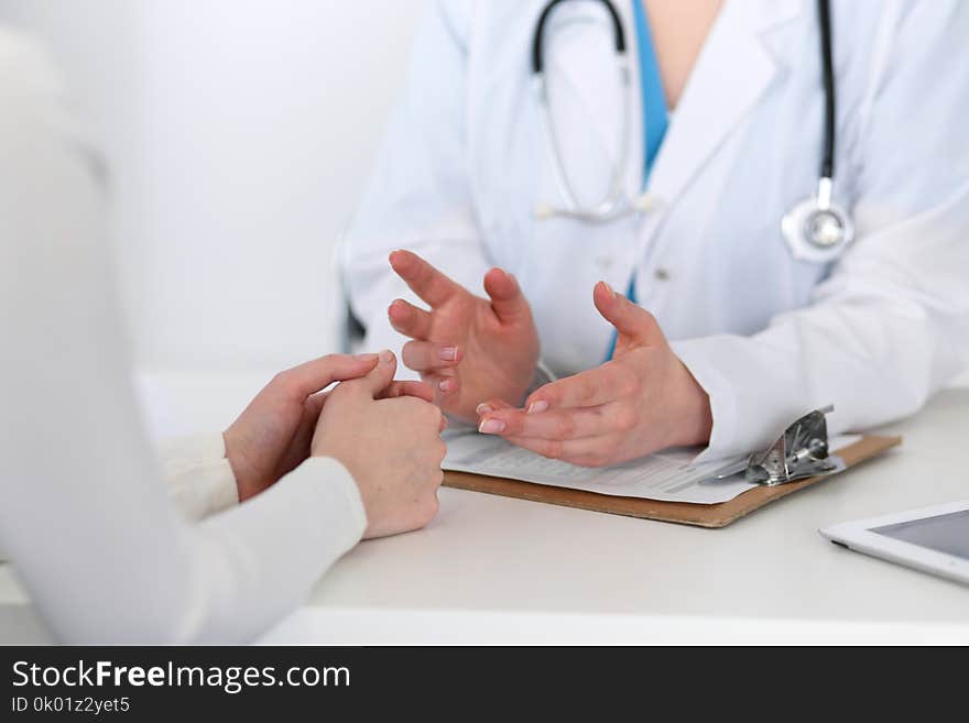 Doctor and patient are discussing something, just hands at the table. Medicine and health care concept