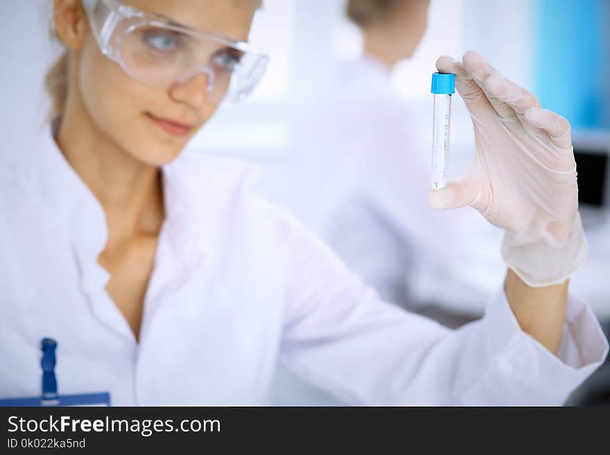 Female scientific researcher in laboratory studying substances or blood sample. Medicine and science concept