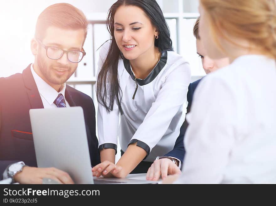 Business people at a meeting in the office. Focus on women pointing into laptop.