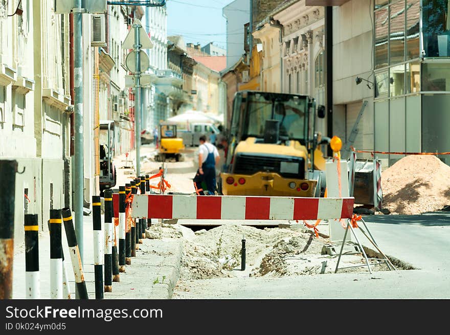 Work ahead street reconstruction site with sign and fence as road barricade