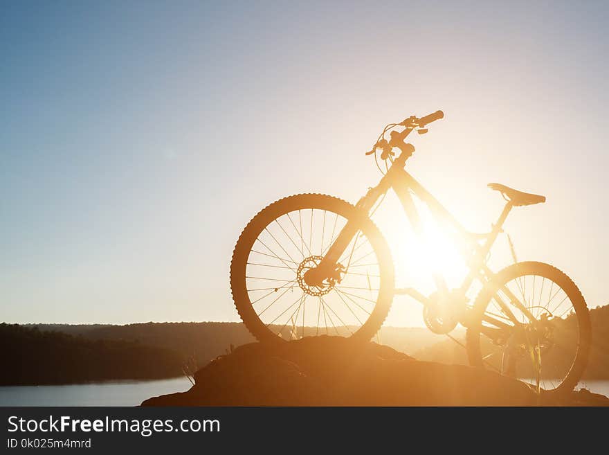 Silhouette Mountain biking on the rock at sky sunset