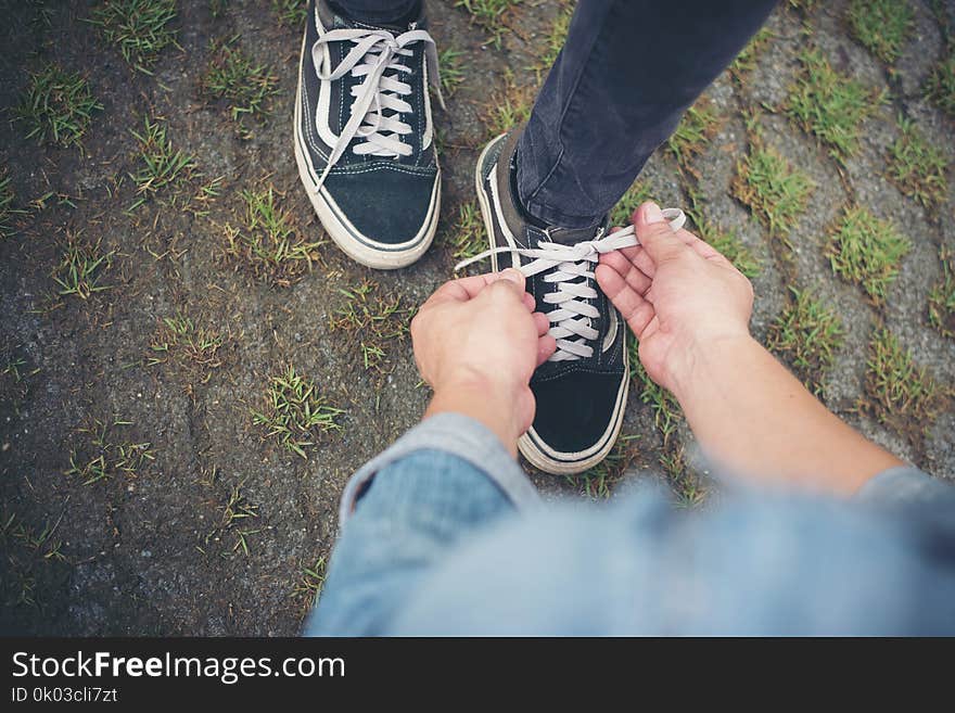 Hipster boyfriend tying shoes to his girls while go the relaxing