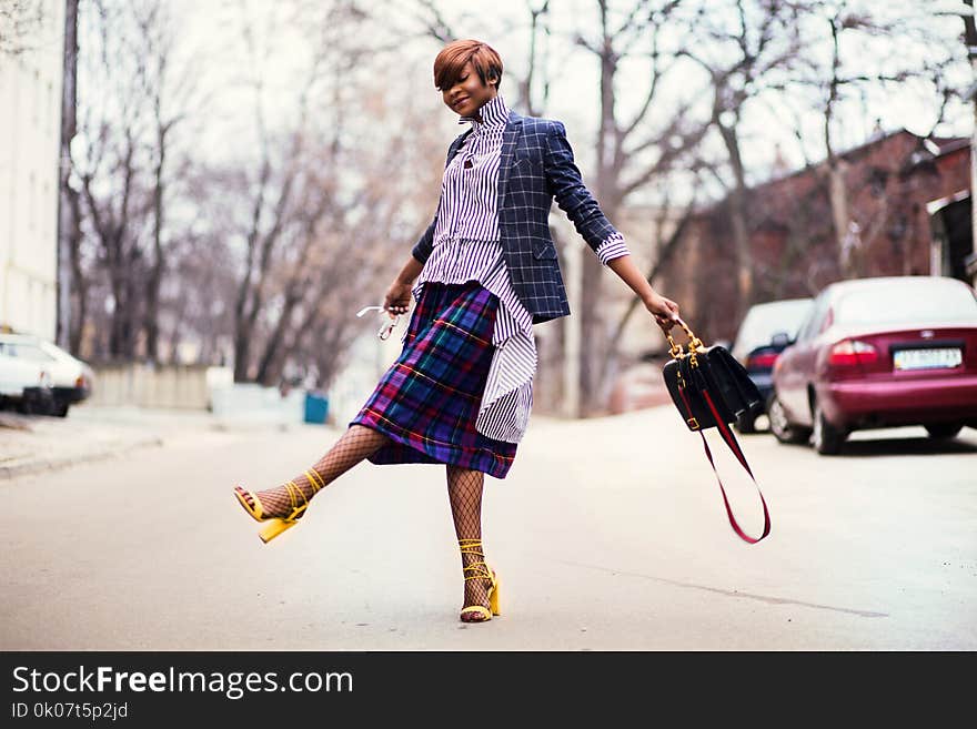 Woman in Purple Top and Plaid Skirt Near Car