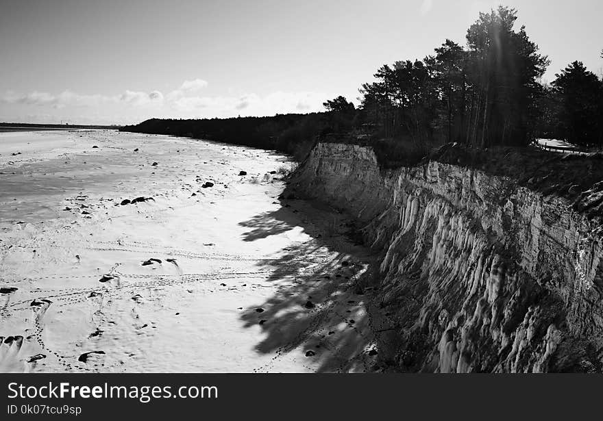 Grayscale Photo of Mountain Cliff Near Ocean