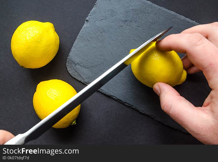 Human Slicing Yellow Lemon