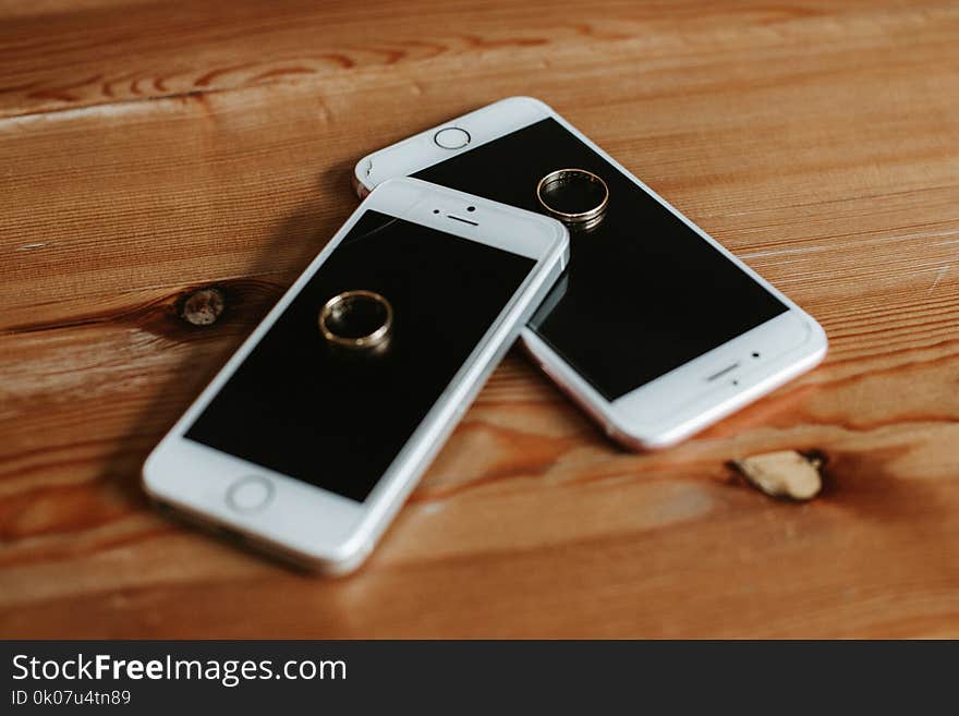 Two Rose Gold Iphone 6s on Brown Wooden Surface