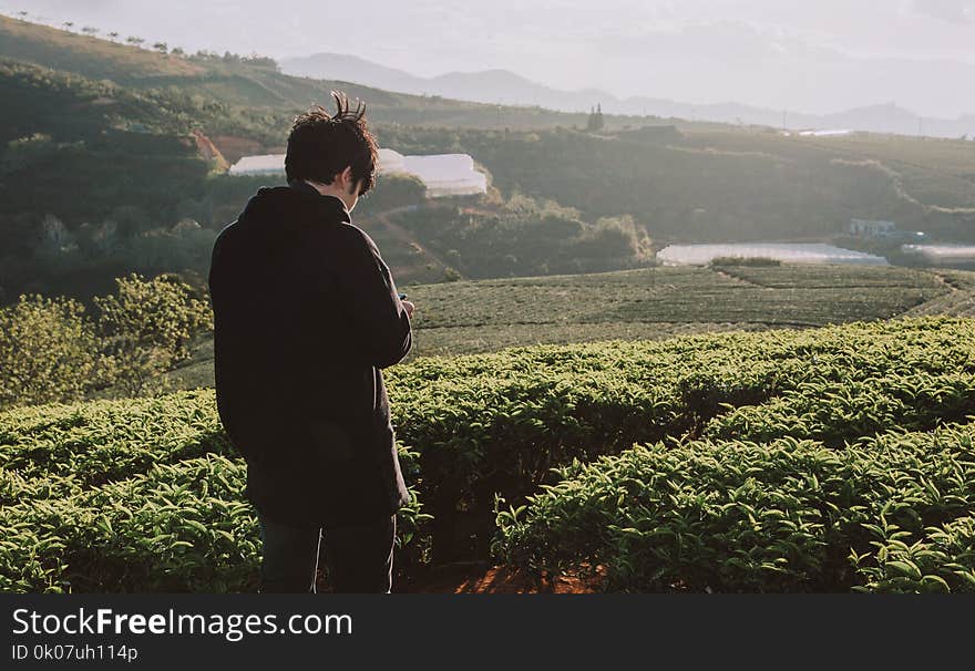 Man Standing on Green Field