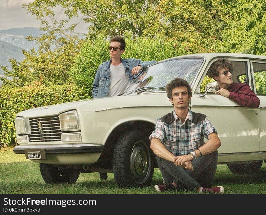 Shallow Focus Photography of Three Men With White Car Surrounded of Trees