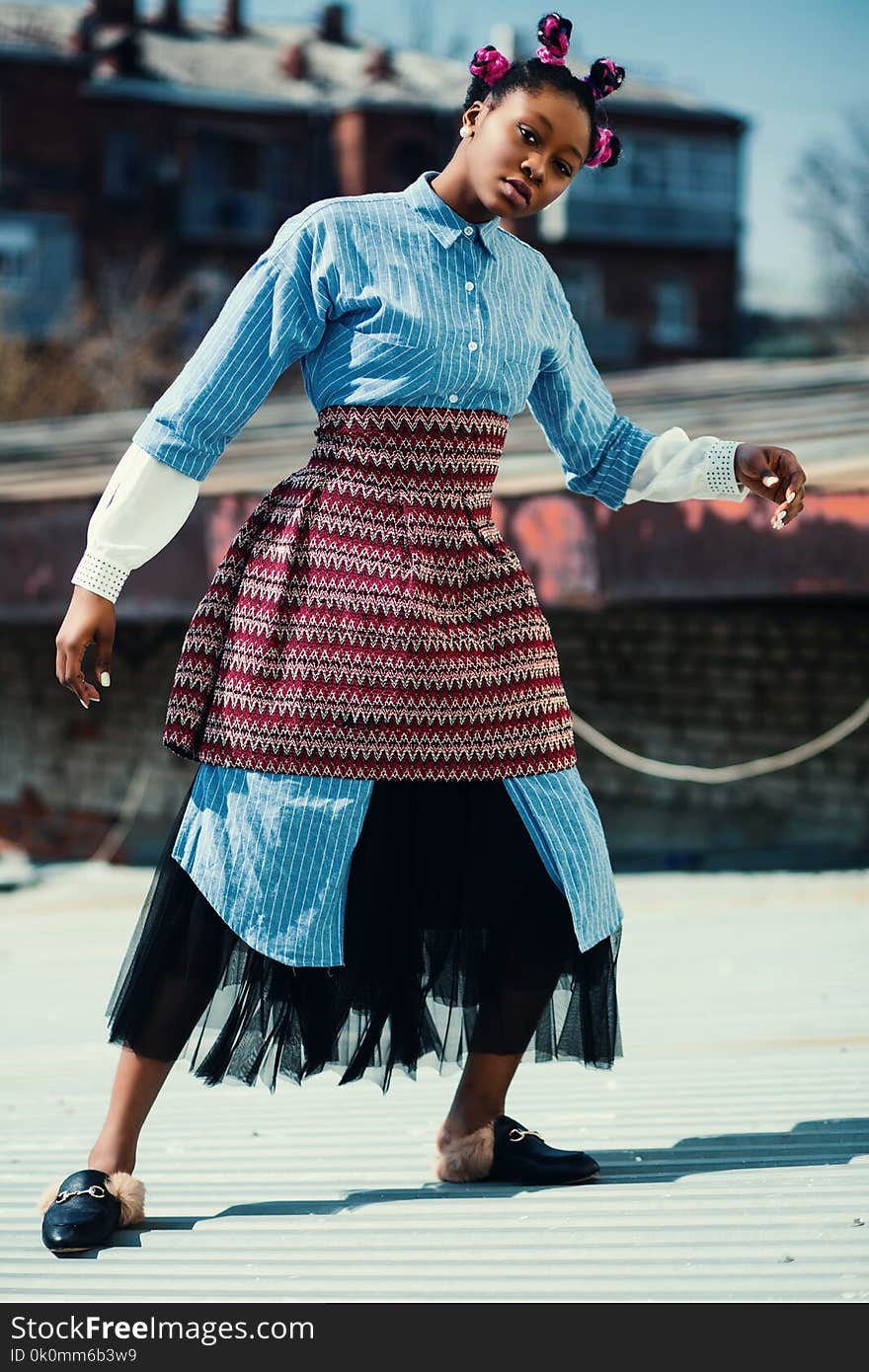 Woman Wearing Blue Long-sleeved Shirt and Red Skirt Standing on Roof