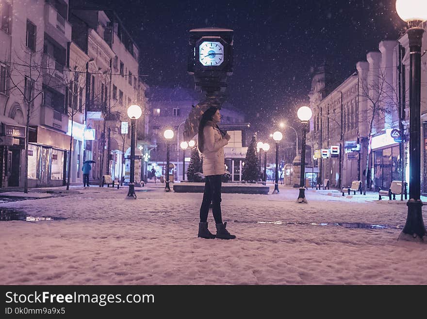 Woman Walking on Street Near Light Post during Winter Season