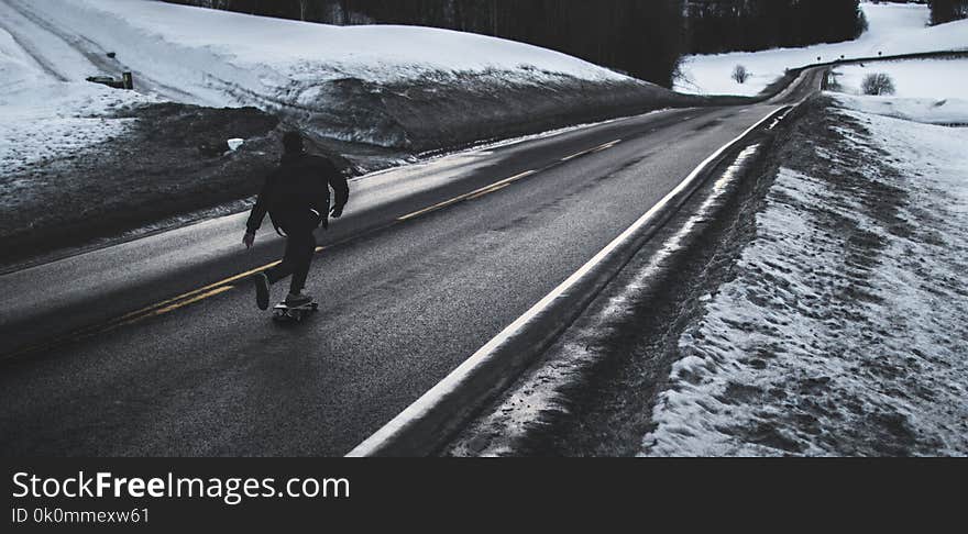 Grayscale Photo of Man Walking on Road