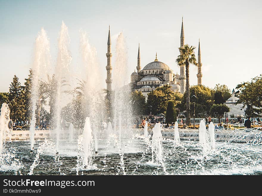 Water Fountain Near White Concrete Dome Building Under White Sky