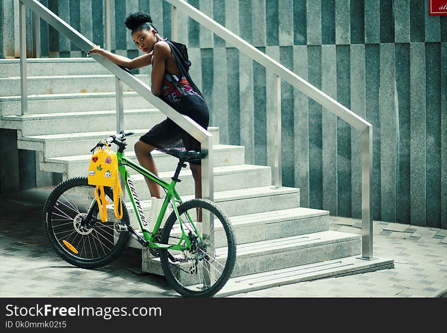 Woman Wearing Gray Sleeveless Hooded Top Standing in the Stair