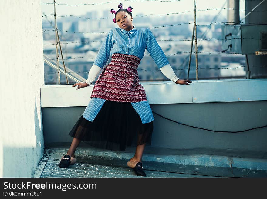 Woman Wearing Blue and Black Long-sleeved Jumpsuit Standing on Roof