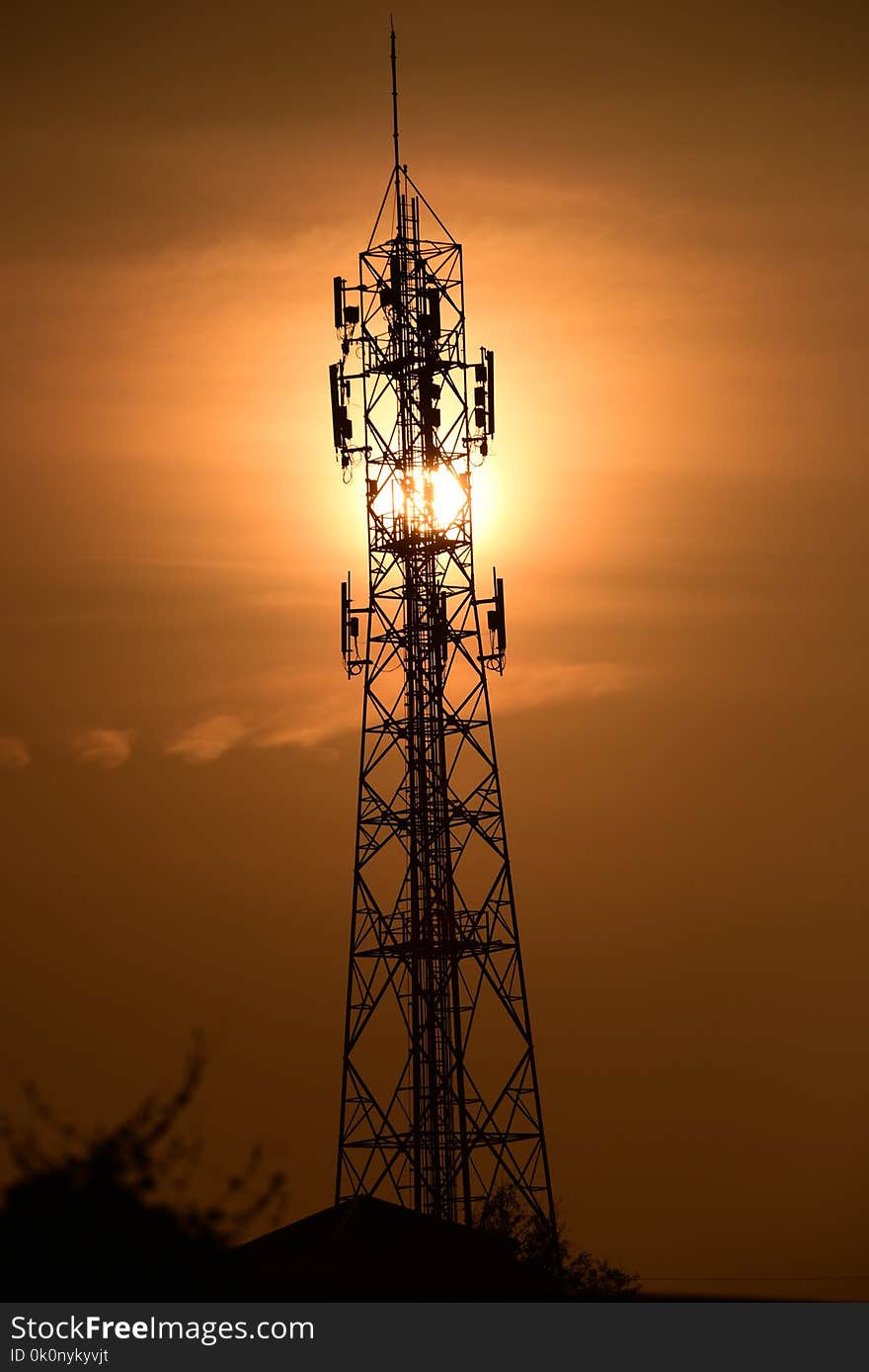 Wireless Communication Antenna With sunrise bright sky.Telecommunication tower with antennas with orange sky.