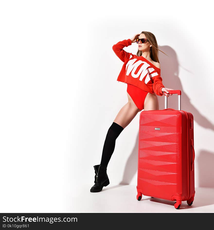 Young woman in fashion red body cloth and hat with traveler luggage bag on white