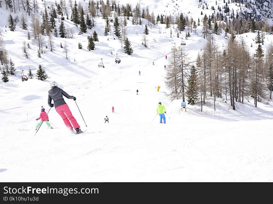 The peaks of the Alps mountains covered with snow. the ski slopes crowded with skiers on a sunny winter day. The peaks of the Alps mountains covered with snow. the ski slopes crowded with skiers on a sunny winter day