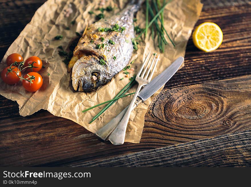 Gilthead seabream & x28;Sparus aurata& x29; baked in the oven with lemon, chive and salt. Gilthead seabream & x28;Sparus aurata& x29; baked in the oven with lemon, chive and salt.