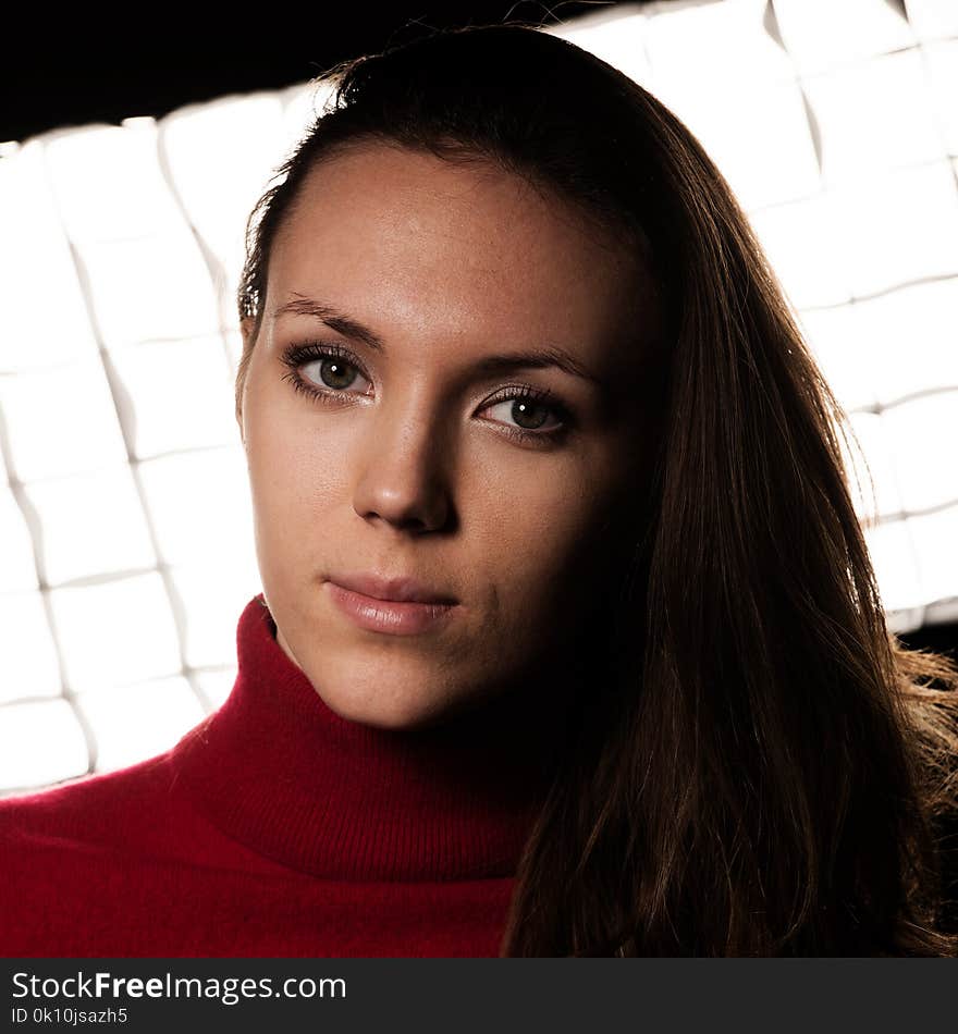 Creaqtive portrait of a beautiful young caucasian happy woman in red wool kneeted sweater .