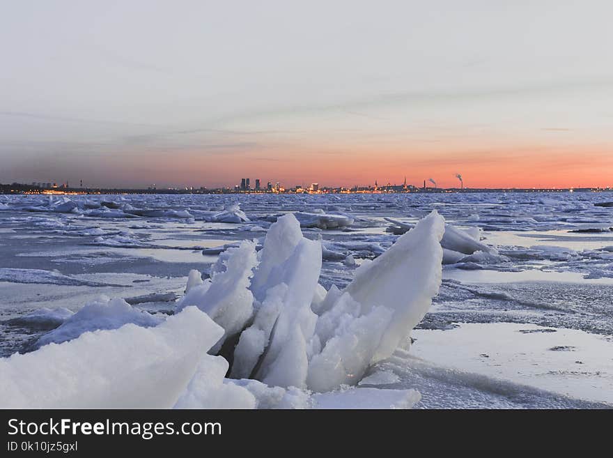 Big pressured ice chunks in front of a sunset view of Estonian`s capital Tallinn. Big pressured ice chunks in front of a sunset view of Estonian`s capital Tallinn