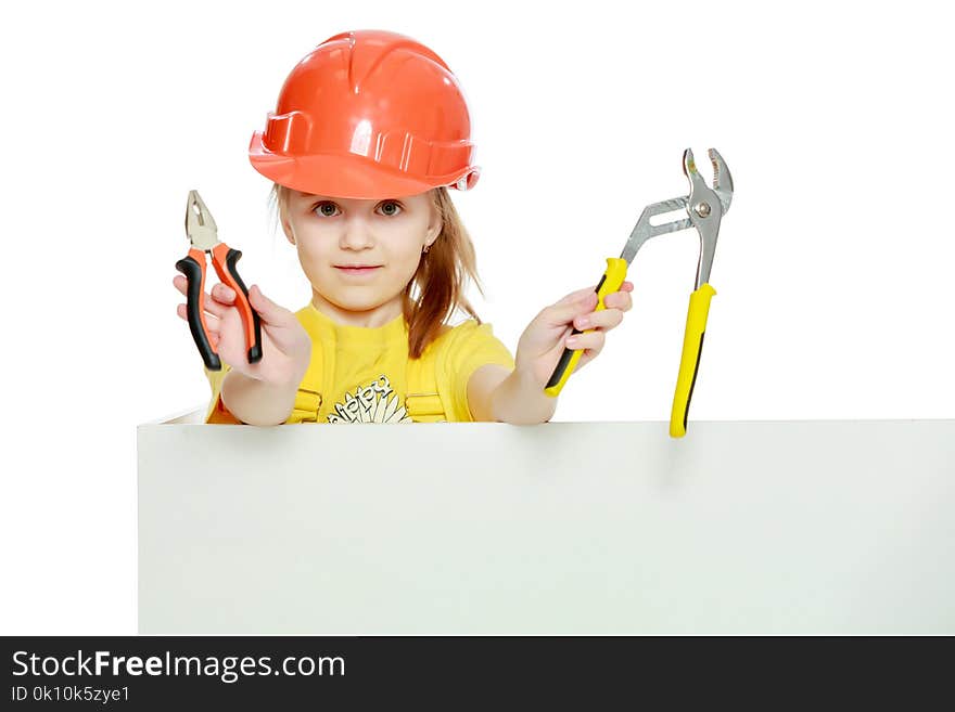 Girl in a construction helmet peeks out from behind a billboard.