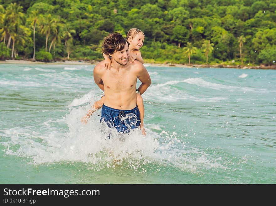 Dad plays with his son in the sea.