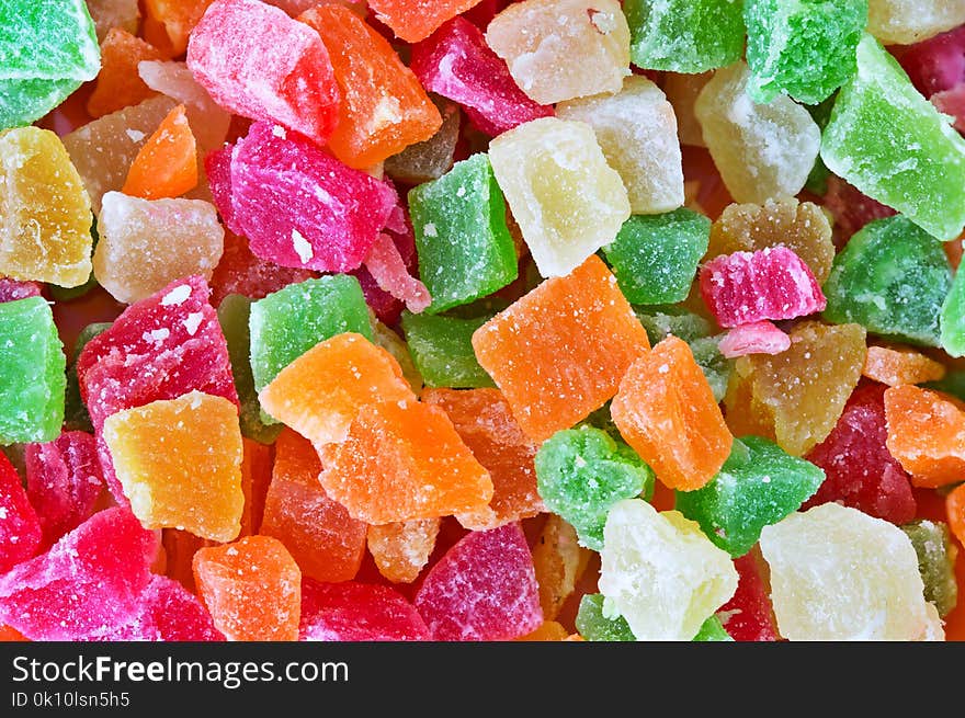 The candied pieces of dried fruit close up. Multi-colored appetizing candied fruits, selective focus