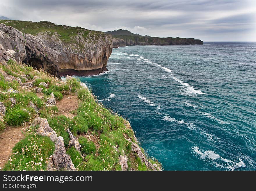 Rocks on the ocean coast in summer cloudy day.