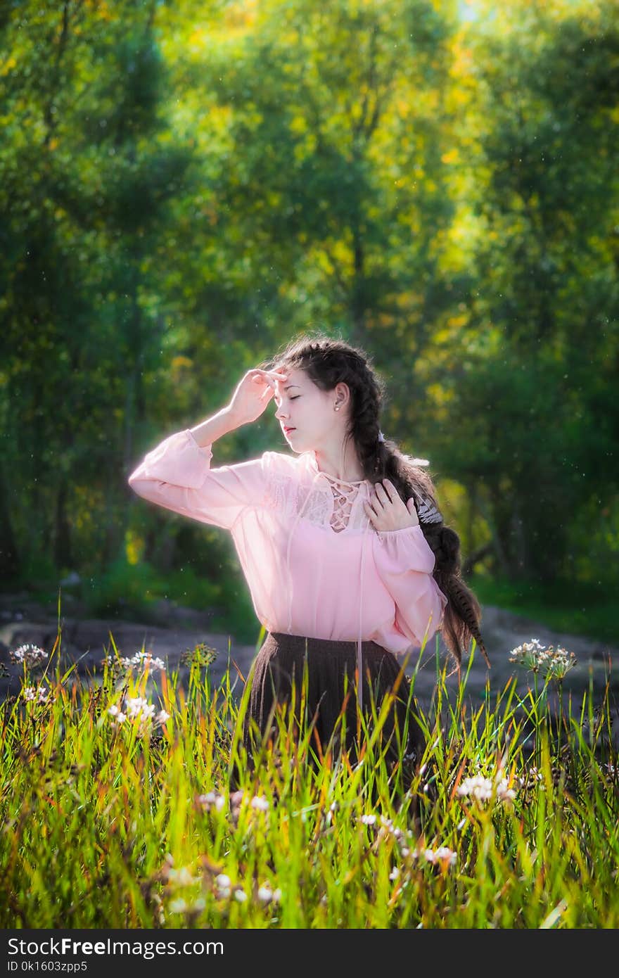 Dreamy girl on a summer sunny day walking in the field of flowers with high grass. Dreamy girl on a summer sunny day walking in the field of flowers with high grass.