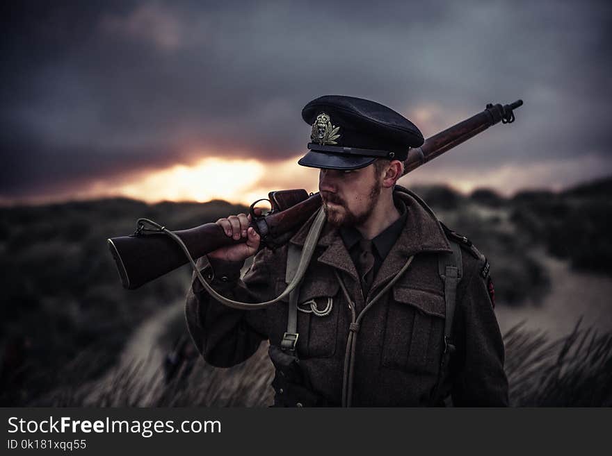 Close-Up Photography of a Man Holding Rifle