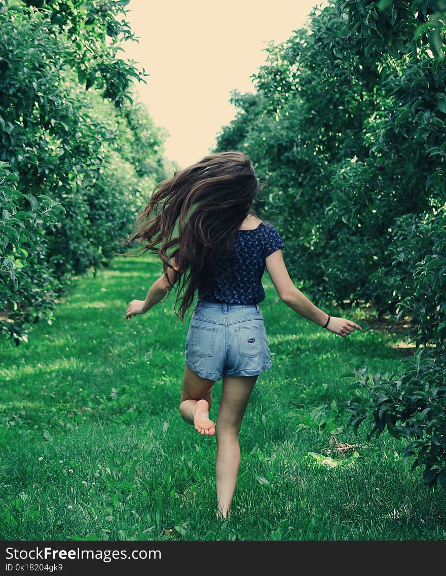 Photo of a Woman Running on Green Grass