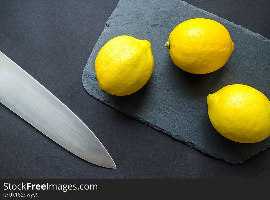 Photo of Three Lemons on Chopping Board Near Knife