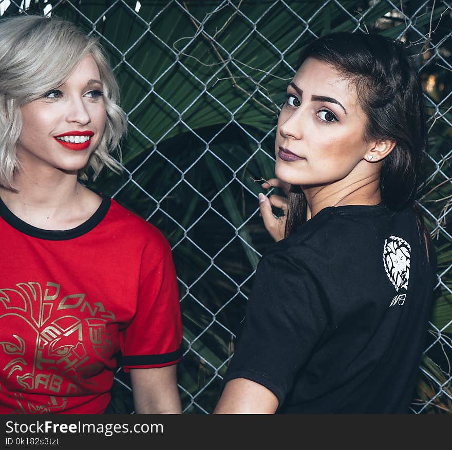 Woman Wearing Black Shirt Beside Woman Wearing Red Shirt