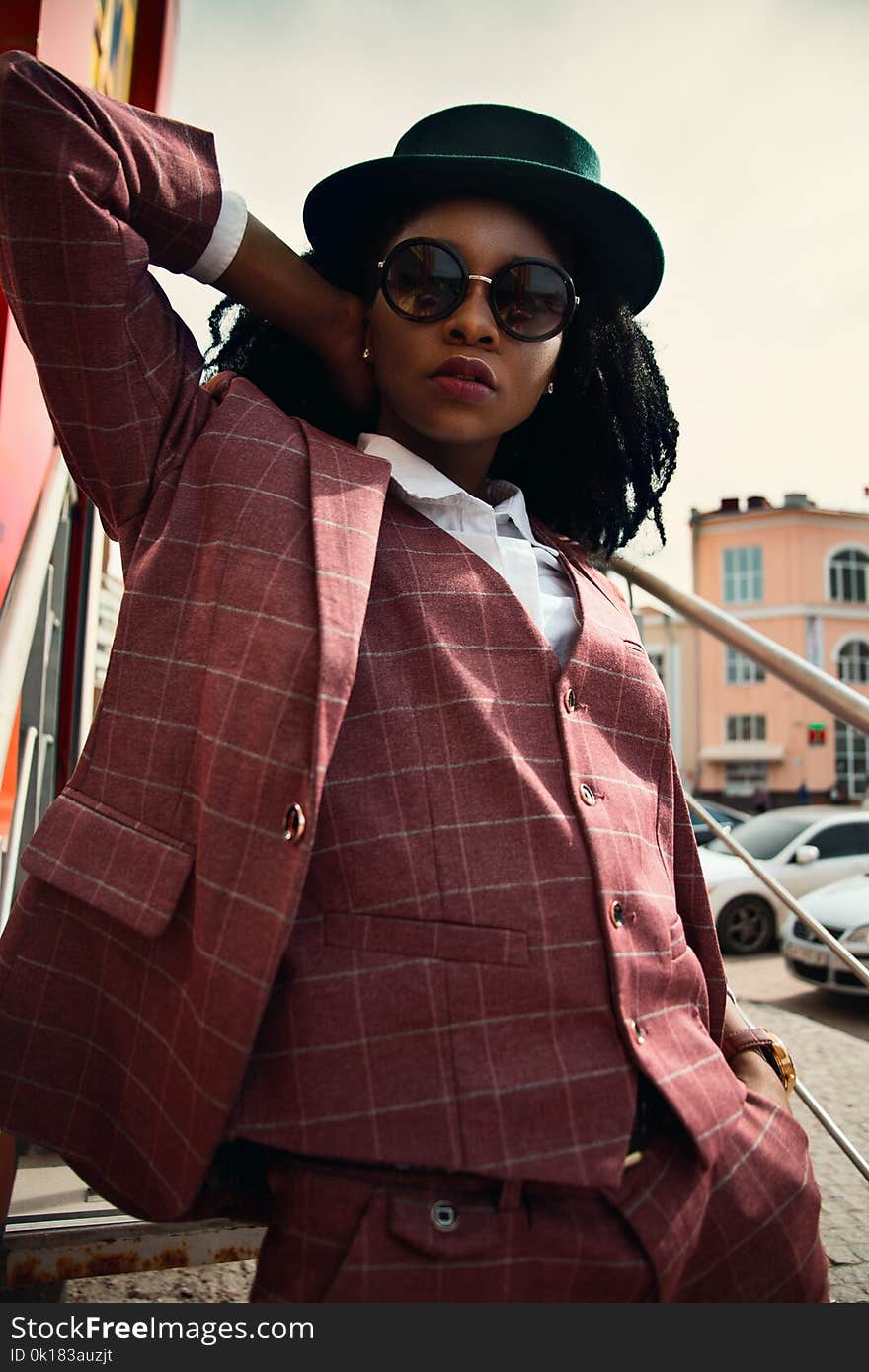 Woman in Maroon Buttoned Coat Wearing Black Hat