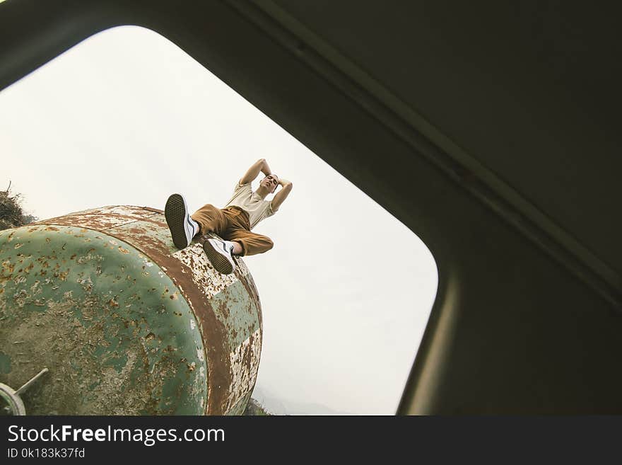 Person Sitting on Green Metal Tank