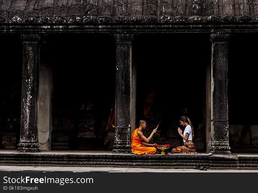 Woman Sitting in Front of Monk