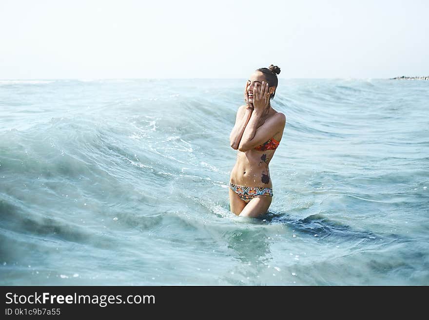 Happy smiling woman swims in the sea and splashed on the waves. Happy smiling woman swims in the sea and splashed on the waves