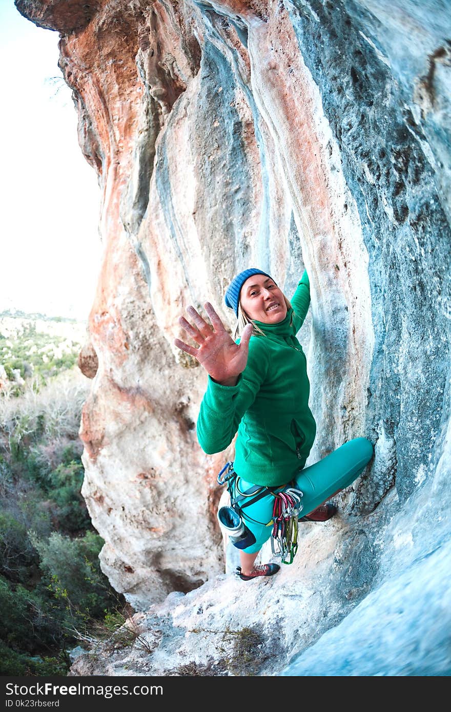 The climber gives five. The woman has overcome the climbing route and is happy with the success. The girl gives five. Gesture of greeting. Fitness in nature.