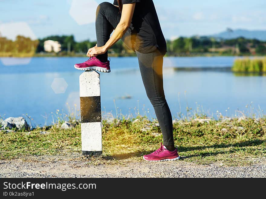 Young woman runner tying shoelaces