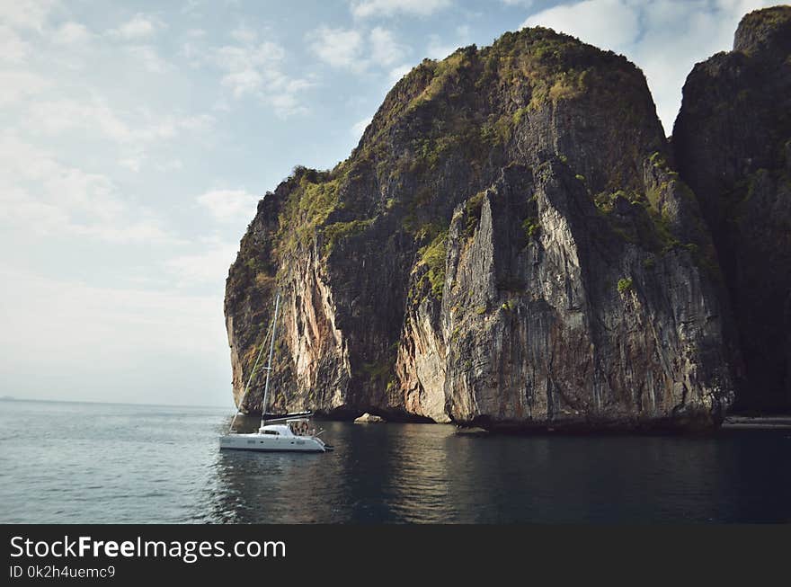 White Sailing Boat Beside Mountain