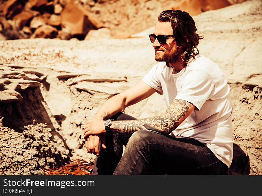 Man Sitting in Brown Stone